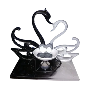 2 cygnes noir et blanc en résine accompagner d'un brûleur de fondants parfumés La coupelle est composée d'un fondant cœur avec 2 mains liées et de 4 petits fondants cœur