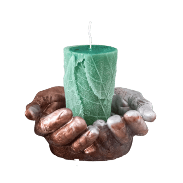Support en résine époxy en forme de deux mains jointes avec au centre une bougie parfumée au motif de feuilles.
